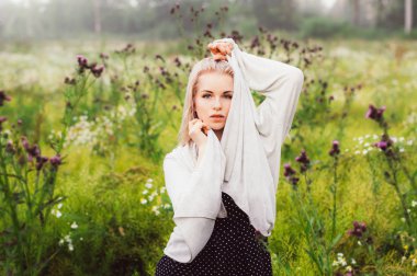 Papatya alanı yakınındaki yüz eller, ilk plan thistle ile dans genç kız portresi