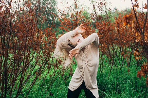 年轻女孩在枯树间跳舞的肖像 双手近脸地运动 — 图库照片