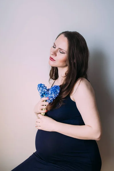 Kobieta Ciąży Zamkniętymi Oczami Ciemno Niebieska Sukienka Siedzi Bukietem Kwiatów — Zdjęcie stockowe