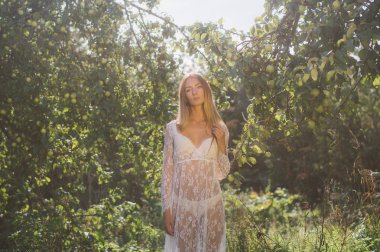 Elma bahçesinde beyaz dantel elbise genç güzel kız