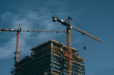 İnşaat alanında, arka planda gökyüzü Vinçler