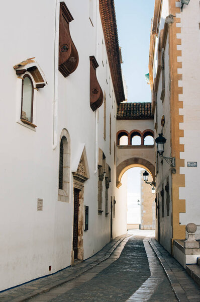 Sitges, Spain - 2017.12.15: Old street with arch in Sitges, The Maricel Museum (Museu de Maricel)