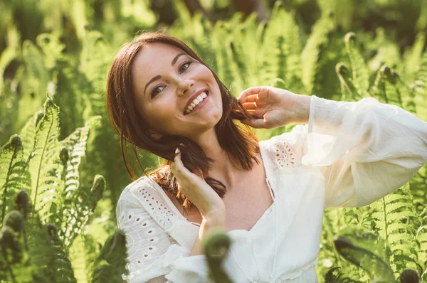 Mooie lachende brunette meisje poseren in fern — Stockfoto