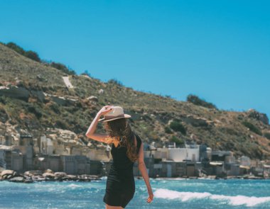 Tarafından geri rüzgarlı sahilde kalan siyah elbiseli kız portresi