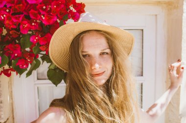 Mor bougainv arasında karışık saçlı gülümseyen kız portresi