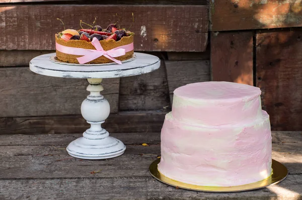 Sajttorta gyümölccsel és bogyós gyümölcsök és nagy rózsaszín torta — Stock Fotó