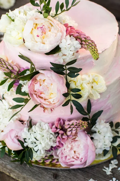 Duży różowy tort weselny ozdobiony kwiatami — Zdjęcie stockowe