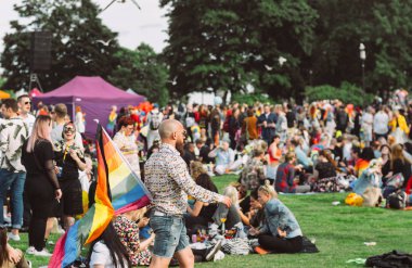 Helsinki Pride festivalinde büyük gökkuşağı bayrağı olan adam
