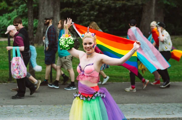 ヘルシンキプライドに虹の旗を持つユニコーンの服を着た女の子 — ストック写真