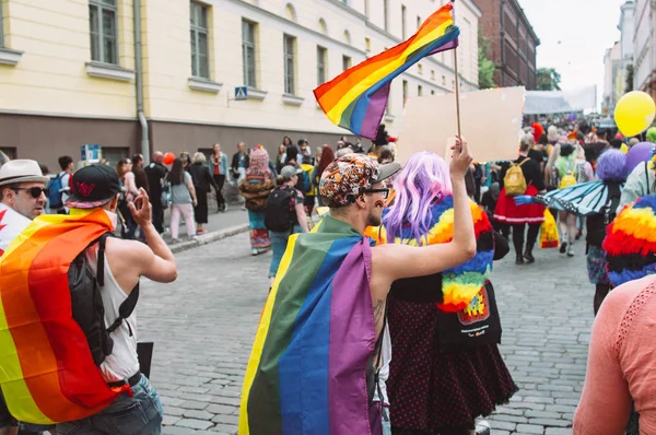 Участники, размахивающие радужным флагом на фестивале Helsinki Pride — стоковое фото