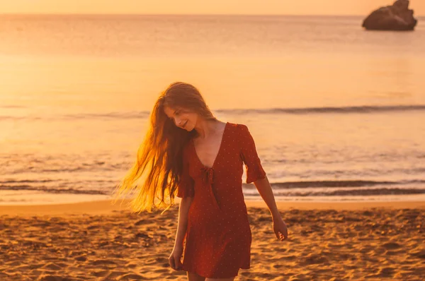 Jonge blonde meisje in rode jurk wandelen in de avond — Stockfoto