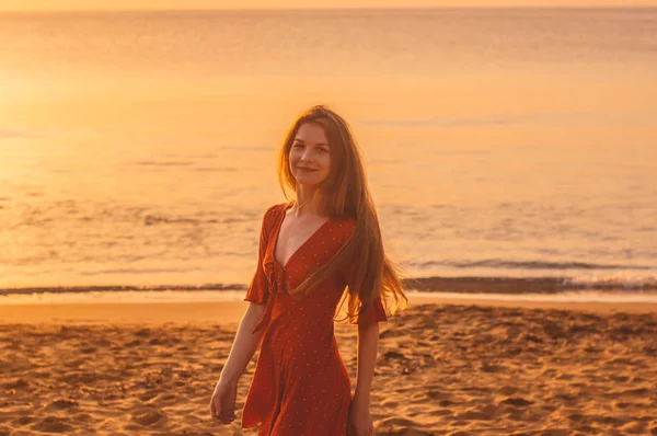 Jonge blonde meisje in rode jurk wandelen in de avond — Stockfoto