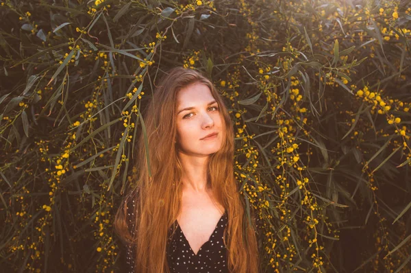 Portret van jonge vrouw tussen takken van boom — Stockfoto