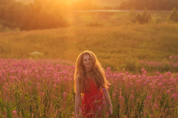 Bailando y saltando sonriente chica en vestido rojo entre floreciente Sal — Foto de Stock