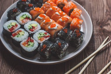 Suşi roll somon, salatalık, yemek çubukları ile avokado, kırmızı havyar. Sushi Menüsü. Japon yemekleri. Bambu peçeteye kapatın