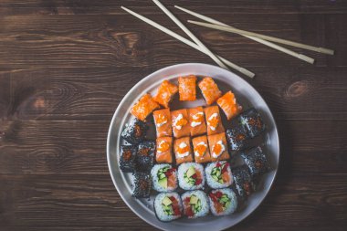 Suşi roll somon, salatalık, yemek çubukları ile avokado, kırmızı havyar. Sushi Menüsü. Japon yemekleri. Bambu peçeteye kapatın