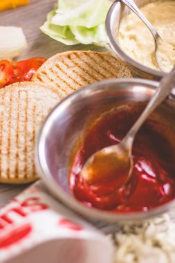 Antika ahşap plaka üzerinde düzenlenen ev yapımı hamburger malzemeler