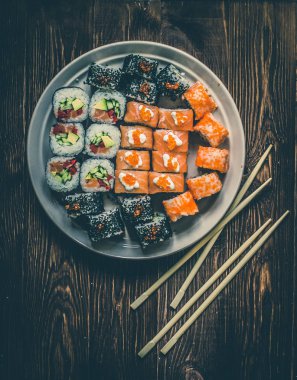 Suşi roll somon, salatalık, yemek çubukları ile avokado, kırmızı havyar. Sushi Menüsü. Japon yemekleri. Bambu peçeteye kapatın