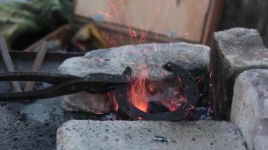 Fabrikada yangında at nalı ısıtma genç bir kadın metalsmith Arka görünümü.
