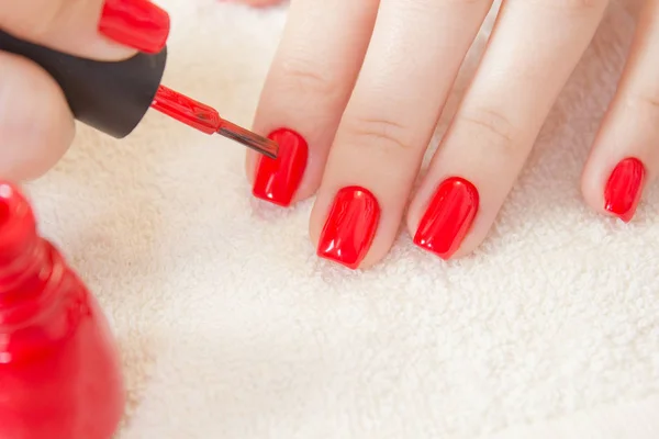 Manicure proces. Nagellak wordt toegepast op de hand, Pools is een rode kleur. Vrouwelijke handen — Stockfoto