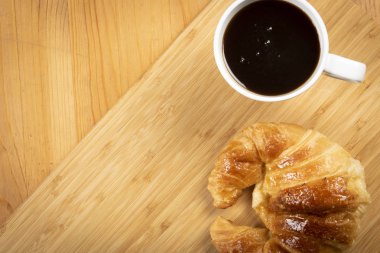Ahşap üzerine kruvasan ile kahve fincan