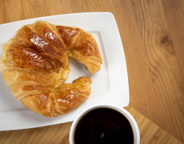 Beyaz tabakta kruvasan ile kahve fincan