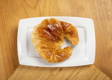 Kruvasan üzerinde beyaz tabak üstten görünüm