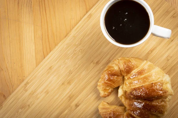 Ahşap üzerine kruvasan ile kahve fincan