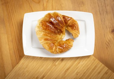 Kruvasan üzerinde beyaz tabak üstten görünüm