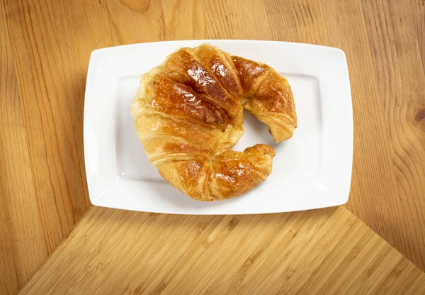 Kruvasan üzerinde beyaz tabak üstten görünüm