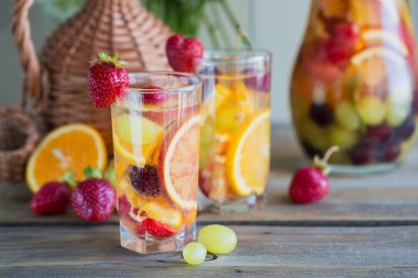 Geleneksel yaz içki beyaz köpüklü şarap sangria. Ev yapımı serinletici meyve sangria veya şampanya, çilek, portakal ve üzüm yumrukla gözlük ve malzemeler ahşap rustik tablo
