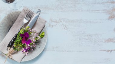 Rustik tablo ayarı ile ışık ahşap masa üzerinde mor çiçekler. Tatil dekorasyon Provence stili. Romantik bir akşam yemeği. Metin kopyalama yeri olan üstten görünüm