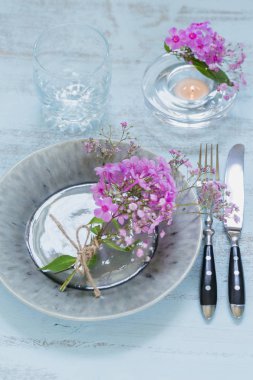 Pembe çiçekli rustik tablo ayarını boş cam ve ahşap masa lambası mum. Tatil dekorasyon Provence stili. Romantik bir akşam yemeği. Düz yatıyordu