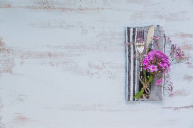 Rustik tablo ayarını hafif ahşap masa üzerinde pembe çiçekli. Tatil dekorasyon Provence stili. Romantik bir akşam yemeği. Metin kopyalama yeri olan üstten görünüm