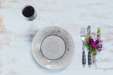 Rustik sofra mor çiçekler ve hafif ahşap masa üzerinde kırmızı şarap ile. Tatil dekorasyon Provence stili. Romantik bir akşam yemeği. Metin kopyalama yeri olan üstten görünüm