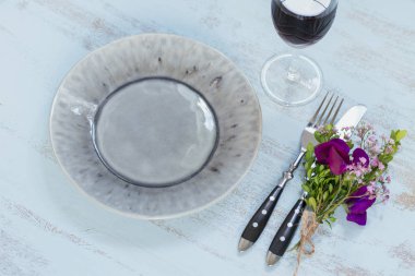 Rustik sofra mor çiçekler ve hafif ahşap masa üzerinde kırmızı şarap ile. Tatil dekorasyon Provence stili. Romantik bir akşam yemeği. Ek yük