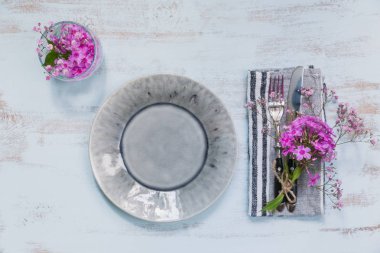 Rustik tablo ayarını hafif ahşap masa üzerinde pembe çiçekli. Tatil dekorasyon Provence stili. Romantik bir akşam yemeği. Metin kopyalama yeri olan üstten görünüm