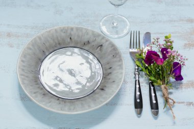 Rustik sofra mor çiçekler ve hafif ahşap masa üzerinde boş şarap kadehi ile. Tatil dekorasyon Provence stili. Romantik bir akşam yemeği. Üstten görünüm