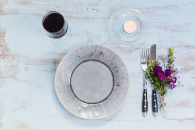 Rustik sofra mor çiçekler, mum ve ahşap masa lambası kırmızı şarap bir bardak. Tatil dekorasyon Provence stili. Romantik bir akşam yemeği. Ek yük