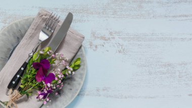 Rustik tablo ayarı ile ışık ahşap masa üzerinde mor çiçekler. Tatil dekorasyon Provence stili. Romantik bir akşam yemeği. Metin kopyalama yeri olan üstten görünüm