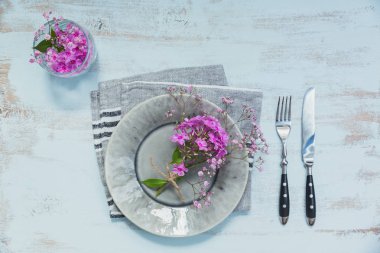 Rustik tablo ayarını hafif ahşap masa üzerinde pembe çiçekli. Tatil dekorasyon Provence stili. Romantik bir akşam yemeği. Metin kopyalama yeri olan üstten görünüm