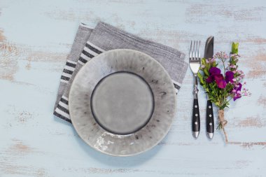 Rustik tablo ayarı ile ışık ahşap masa üzerinde mor çiçekler. Tatil dekorasyon Provence stili. Romantik bir akşam yemeği. Metin kopyalama yeri olan üstten görünüm