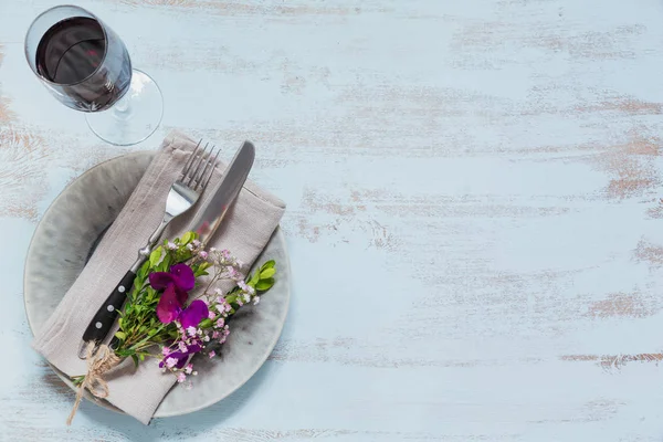Rustik sofra mor çiçekler ve hafif ahşap masa üzerinde kırmızı şarap ile. Tatil dekorasyon Provence stili. Romantik bir akşam yemeği. Metin kopyalama yeri olan üstten görünüm