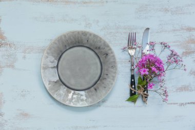 Rustik tablo ayarını hafif ahşap masa üzerinde pembe çiçekli. Tatil dekorasyon Provence stili. Romantik bir akşam yemeği. Üstten görünüm 