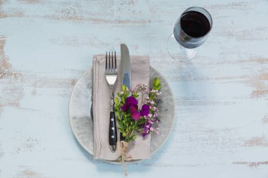 Rustik sofra mor çiçekler ve hafif ahşap masa üzerinde kırmızı şarap ile. Tatil dekorasyon Provence stili. Romantik bir akşam yemeği. Metin kopyalama yeri olan üstten görünüm