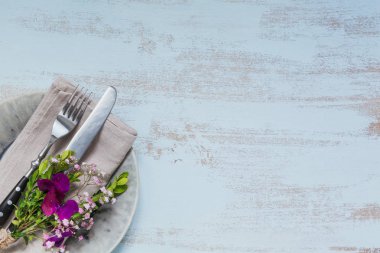 Rustik tablo ayarı ile ışık ahşap masa üzerinde mor çiçekler. Tatil dekorasyon Provence stili. Romantik bir akşam yemeği. Metin kopyalama yeri olan üstten görünüm