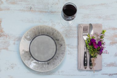 Rustik sofra mor çiçekler ve hafif ahşap masa üzerinde kırmızı şarap ile. Tatil dekorasyon Provence stili. Romantik bir akşam yemeği. Düz yatıyordu