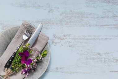 Rustik tablo ayarı ile ışık ahşap masa üzerinde mor çiçekler. Tatil dekorasyon Provence stili. Romantik bir akşam yemeği. Metin kopyalama yeri olan üstten görünüm