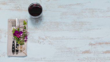 Rustik sofra mor çiçekler ve hafif ahşap masa üzerinde kırmızı şarap ile. Tatil dekorasyon Provence stili. Romantik bir akşam yemeği. Metin kopyalama yeri olan üstten görünüm