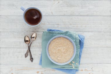 Yulaf lapası kase Beyaz ahşap zemin üzerinde. Sağlıklı besleyici kahvaltı. Kavramı, sağlıklı beslenme, diyet. Düz yatıyordu